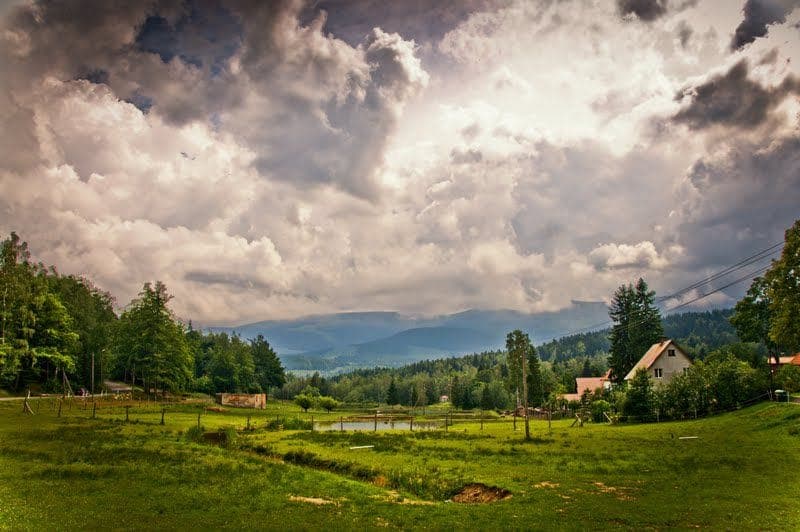 Zelená louka a Krkonoše pod mraky u Drewniana Róża